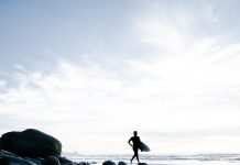 A chat with Ra Collective ~ Trudi Hsu a person with a surfboard walking on a beach